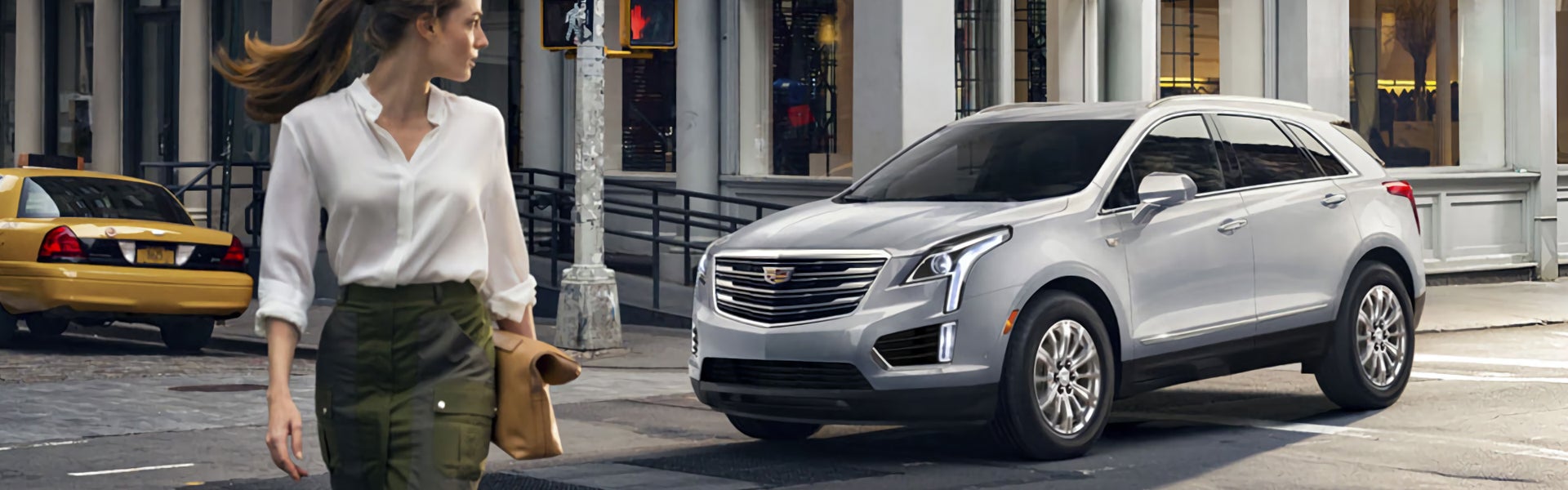Woman walking away from silver 2019 Cadillac XT5