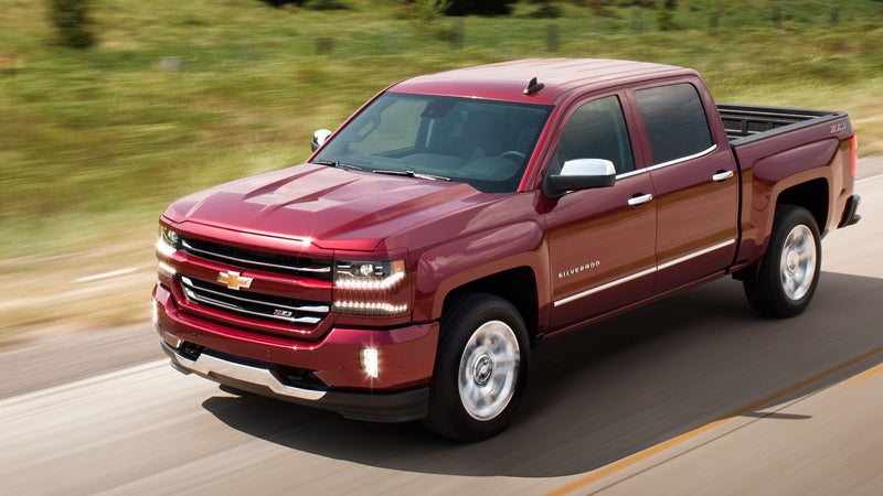 Red 2018 Chevy Silverado driving in grassy area