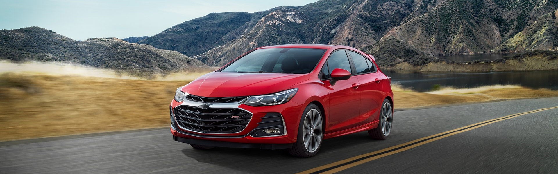 Red Chevy Cruze driving in mountains