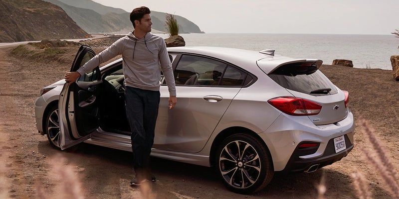 Couple exiting white Chevy Cruze on shore