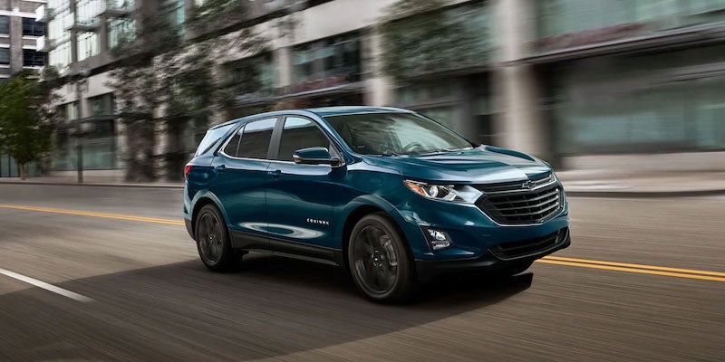 Blue 2021 Chevy Equinox driving through city