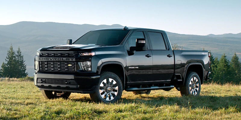 Black 2021 Chevy Silverado 2500 in field among mountains