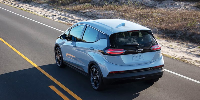 White 2022 Chevy Bolt EV driving on country road