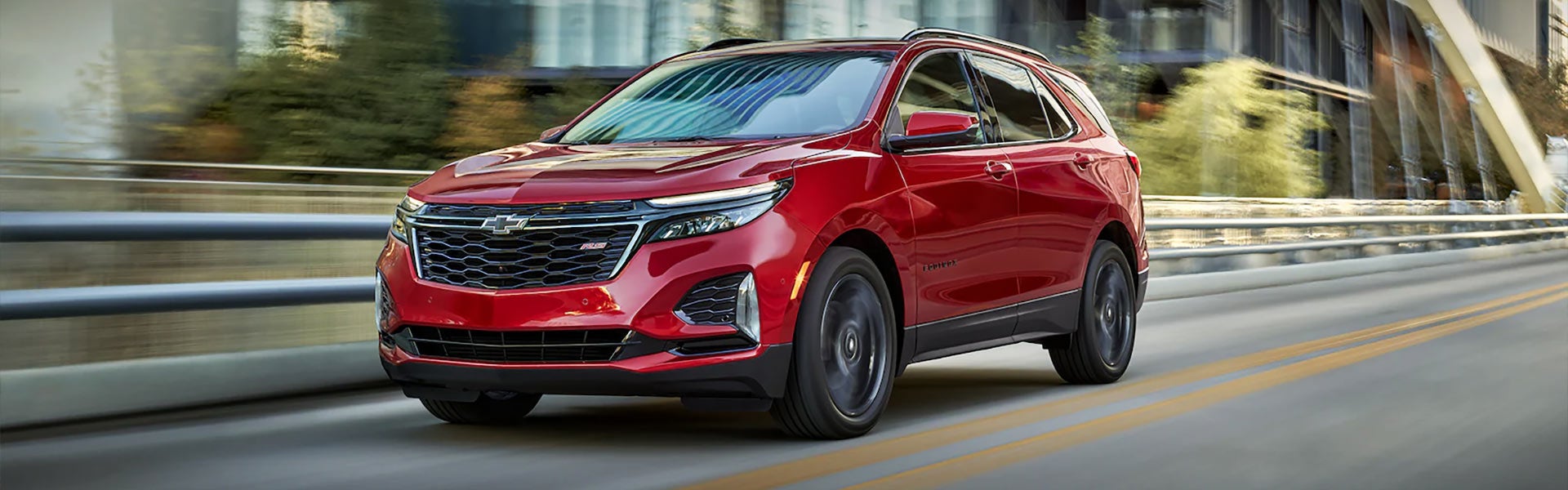 Red Chevrolet Equinox driving urban roads