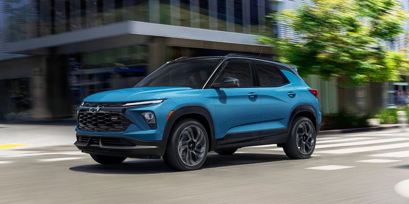 Blue Chevrolet Trailblazer driving down the street at high speed into the city