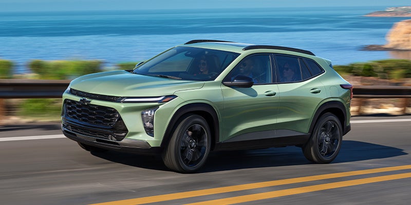 Green Trax driving down the highway at a high speed next to an ocean