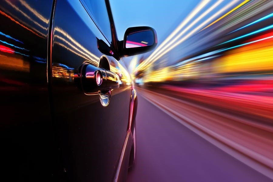 Chevrolet Vehicle going at high speeds across the bright city lights