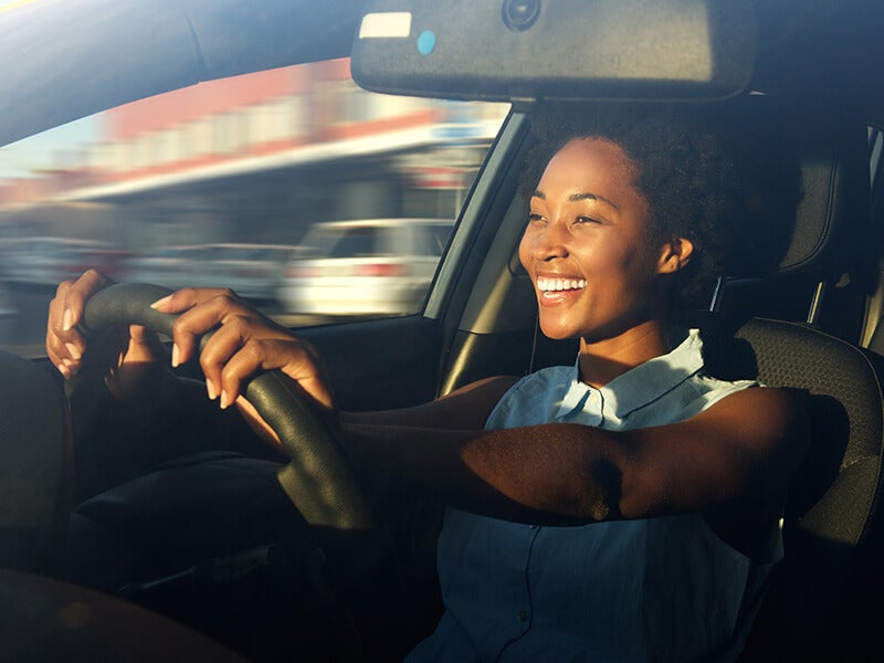 Happy woman driving from Murdock Manhattan Chevrolet after demoing a car