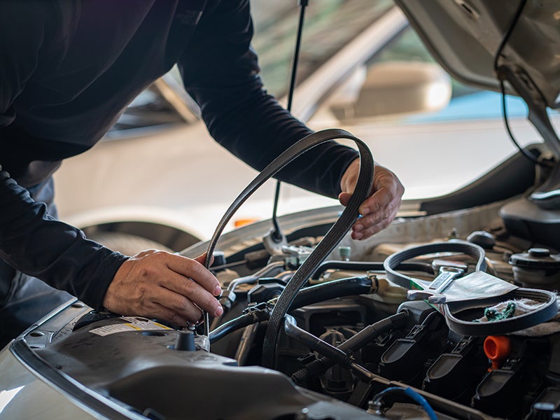 Mechanic changing car belt Murdock Manhattan Chevrolet dealership