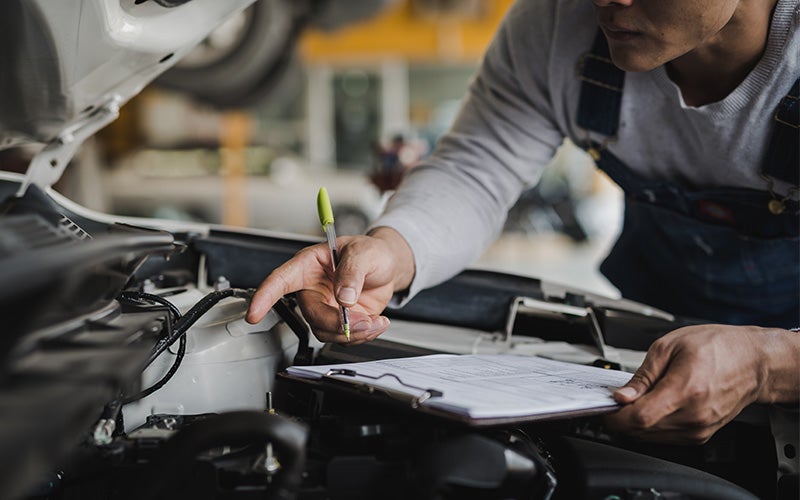 inspecting the engine and oil at Murdock Manhattan Chevrolet