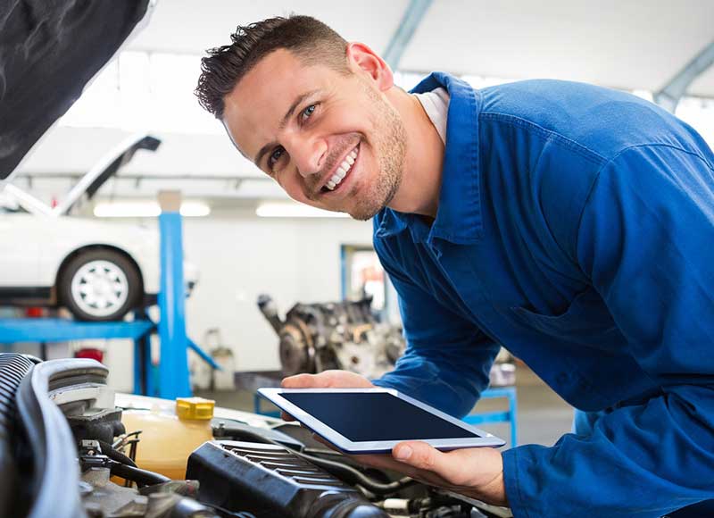 Technican smiling as he checks what is wrong with the Chevrolet vehicle at Murdock Manhattan Chevrolet