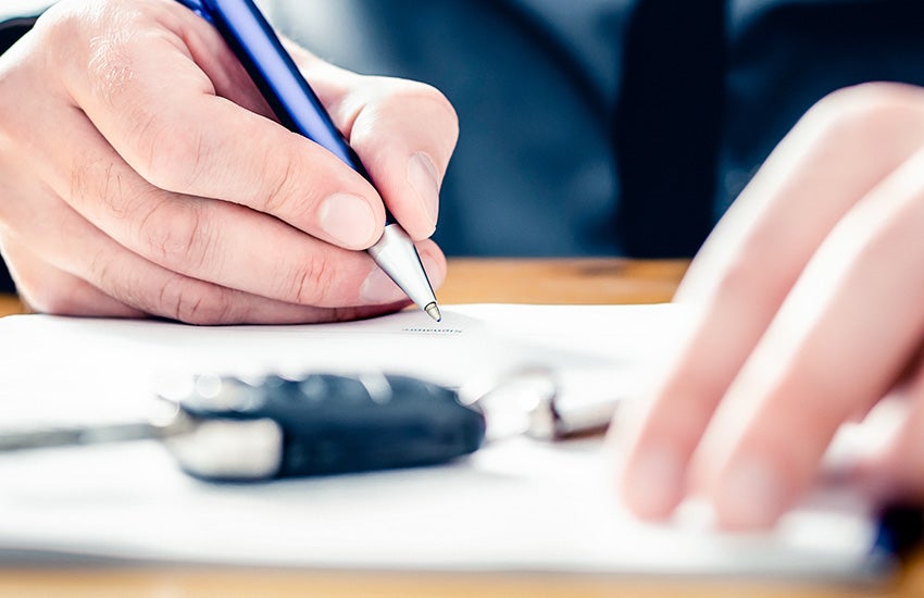 Man signing a form after financing a used car at Murdock Manhattan Chevrolet